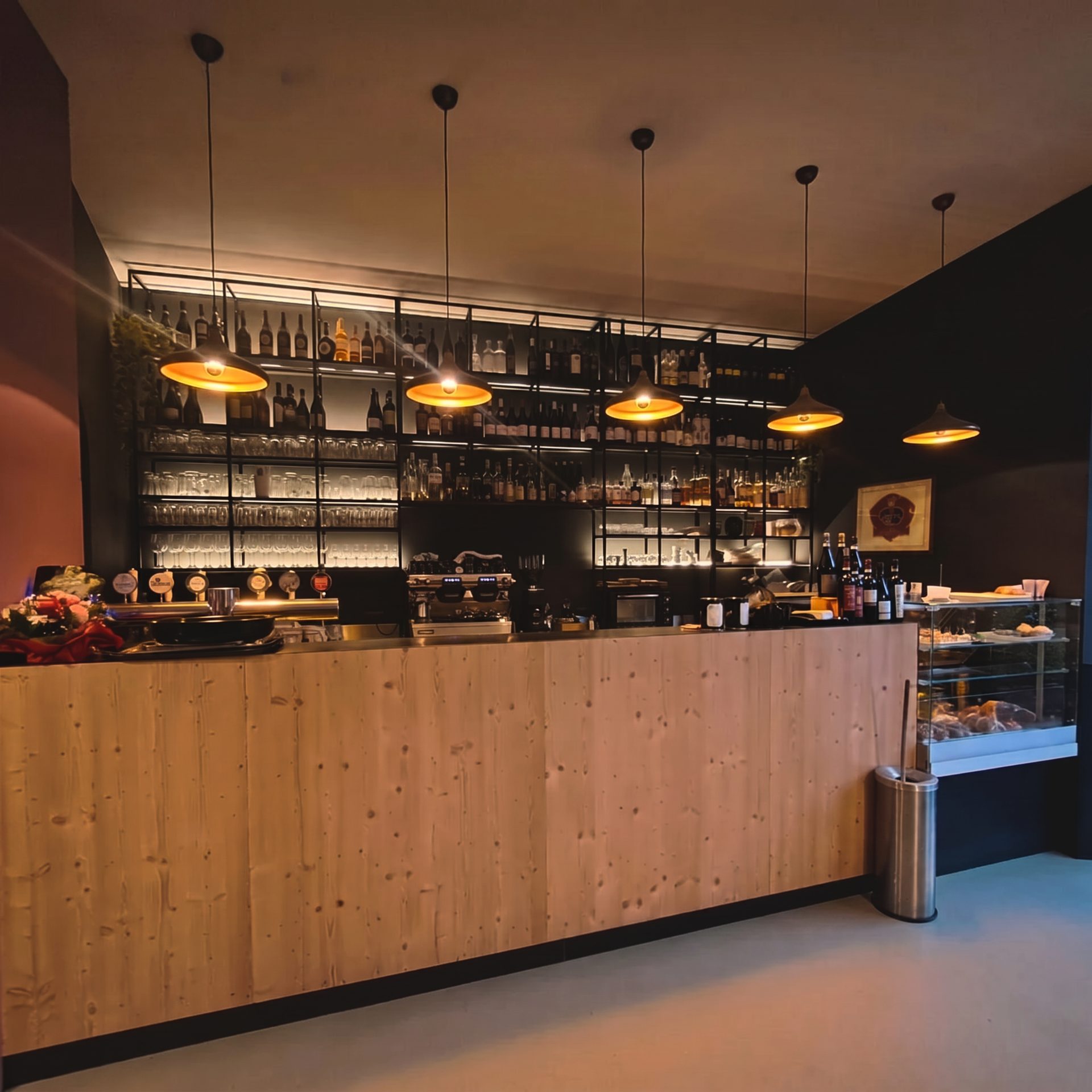 Il bancone dell'Osteria Riki & Mauri illuminato dalle lampade a campana